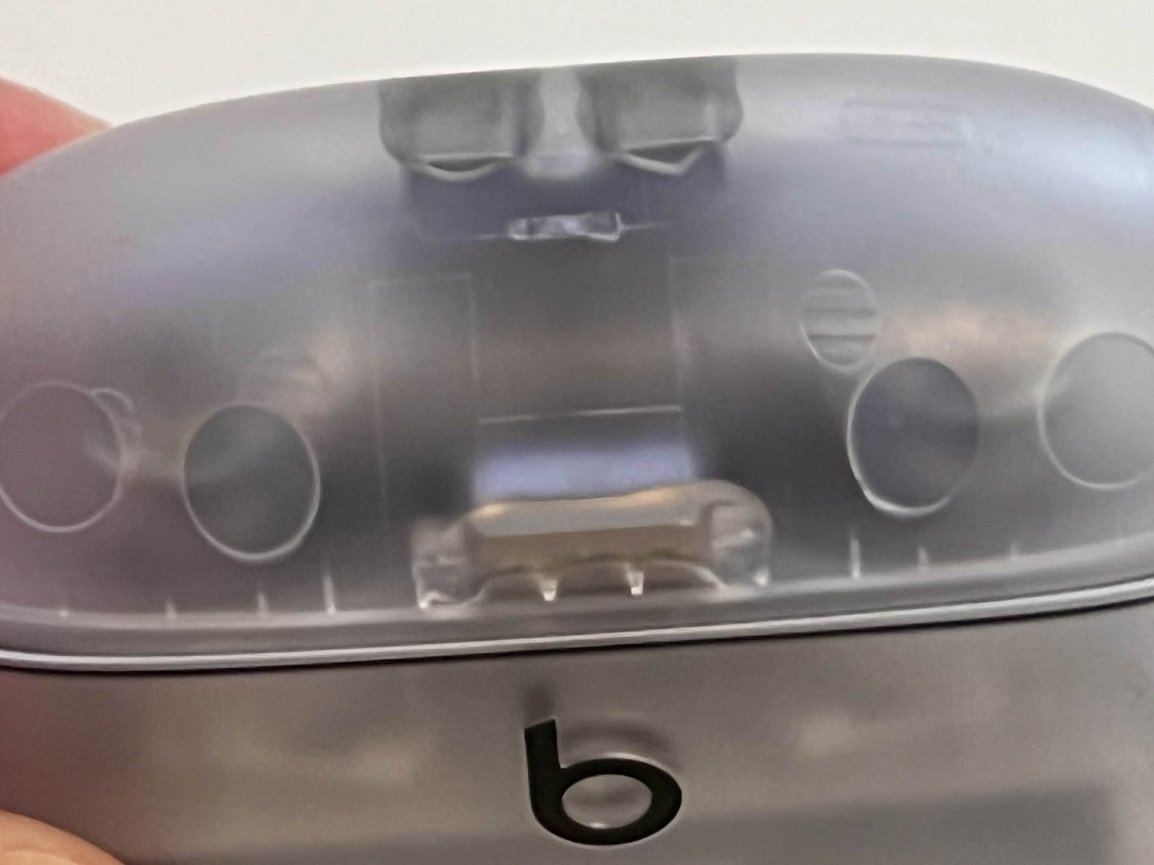 A close up photo of the glue visible through the top transparent case of the Beats Studio Buds+