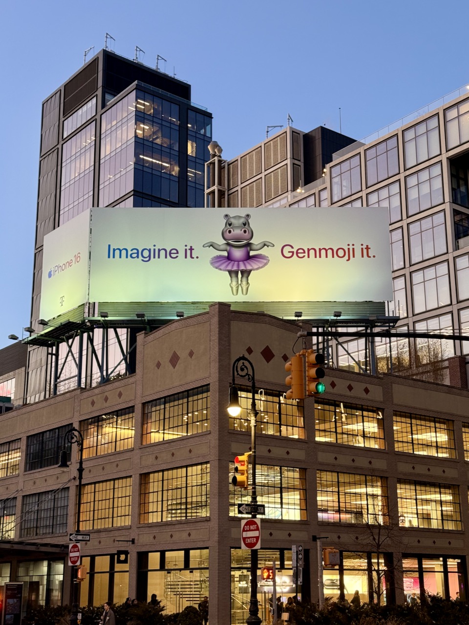 A photo of the Chelsea Apple Store in Manhattan with a huge billboard showcasing a dancing hippo Genmoji