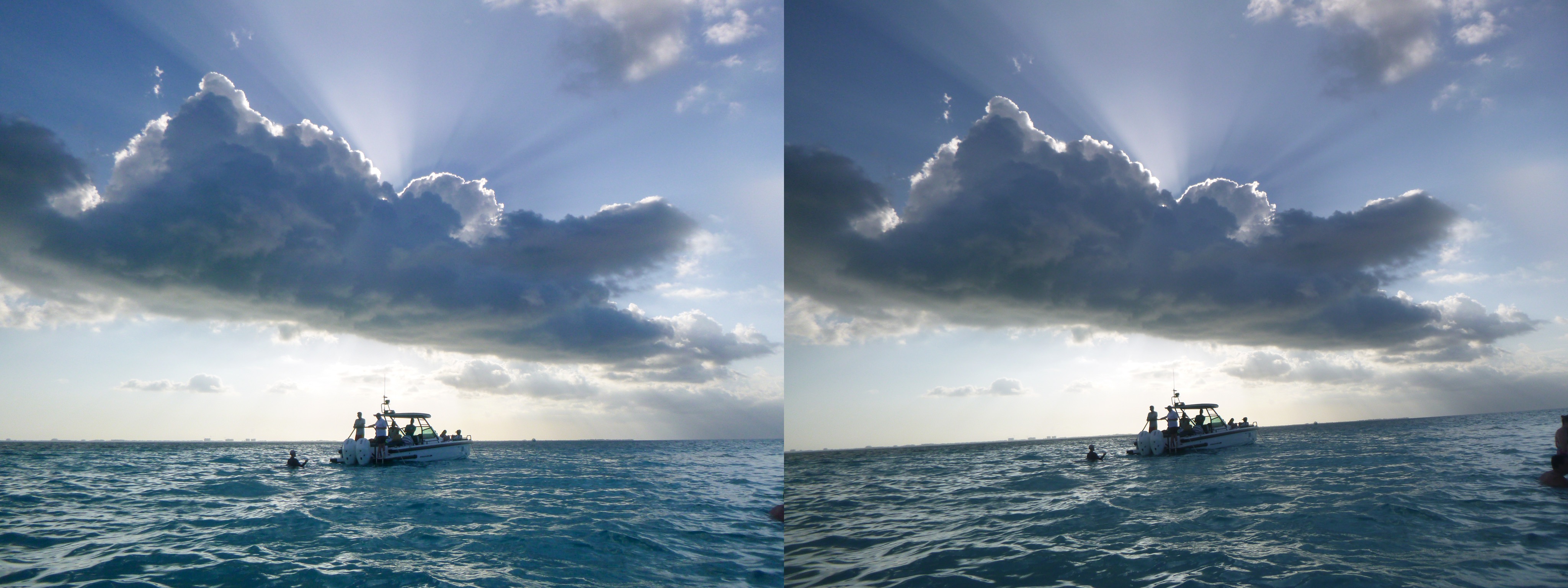 A photo of a boat with a puffy cloud above it backlit by the sun. Sun rays stream above frame. Unedited photo with bad horizon line.