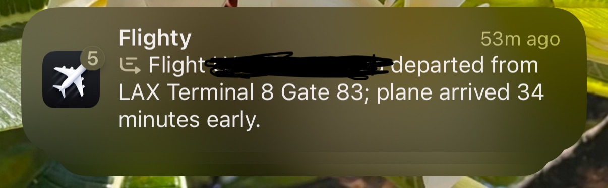 Flighty notification. Summarization glyph. Flight [redacted] departed from LAX terminal 8 Gate 83; plane arrived 34 minutes early.